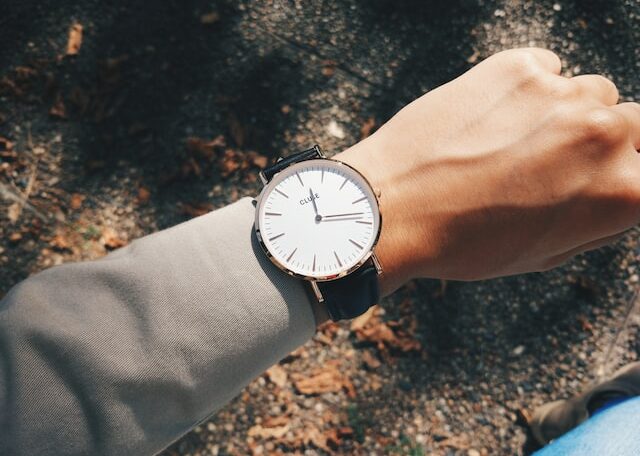 person wearing round silver-colored analog watch